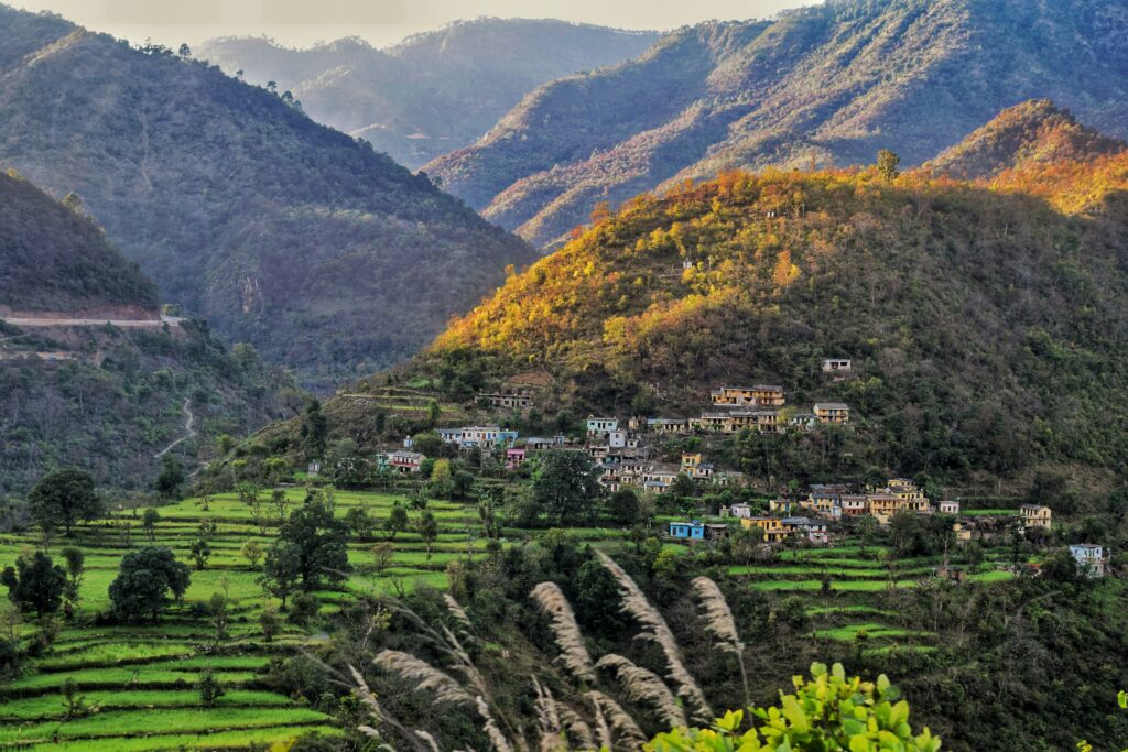 A serene view of a village in Rishikesh, India, with Himalayan foothills, ideal for value wellness travel 2025