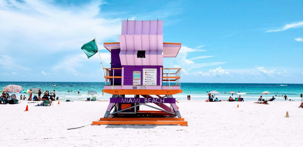 A lively South Beach in Miami with golden sands and colorful lifeguard towers, a top value beach travel 2025 spot