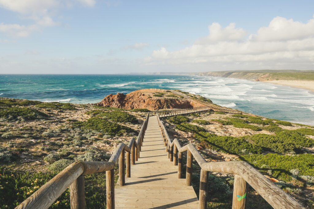 A golden beach in Algarve, Portugal, with calm waves, ideal for value wellness travel 2025 surfing and relaxation