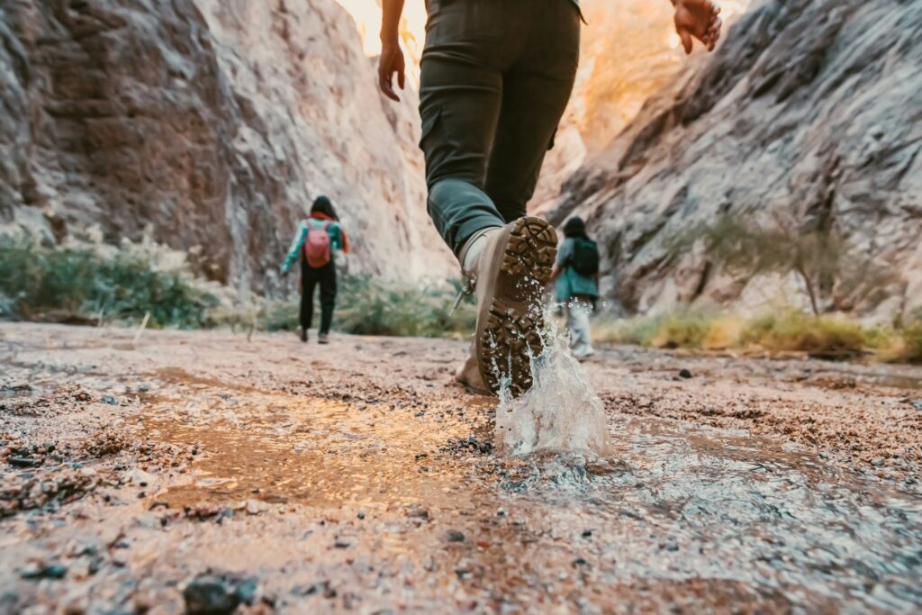 A rugged mountain peak at sunrise with a hiker overlooking a vast valley, showcasing value adventure travel 2025