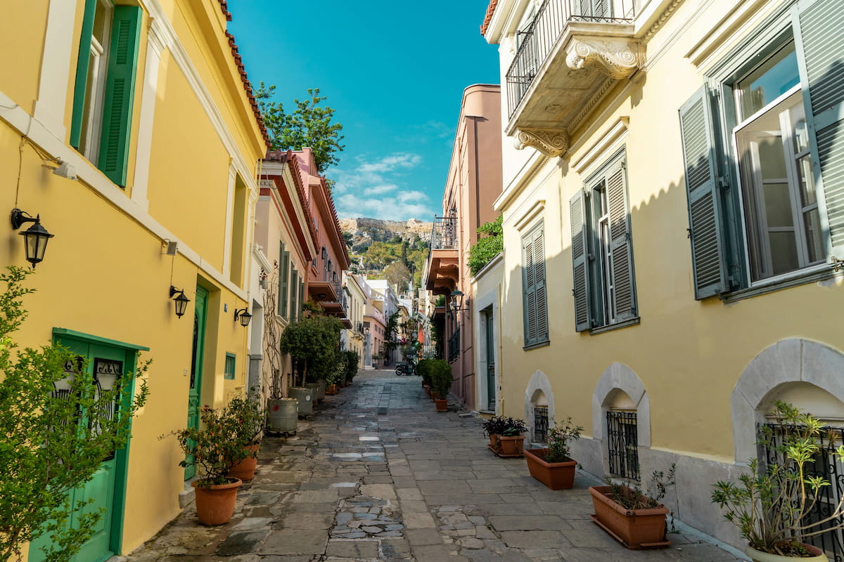 Plaka neighborhood streets in Athens with bougainvillea, outdoor cafes, and neoclassical architecture