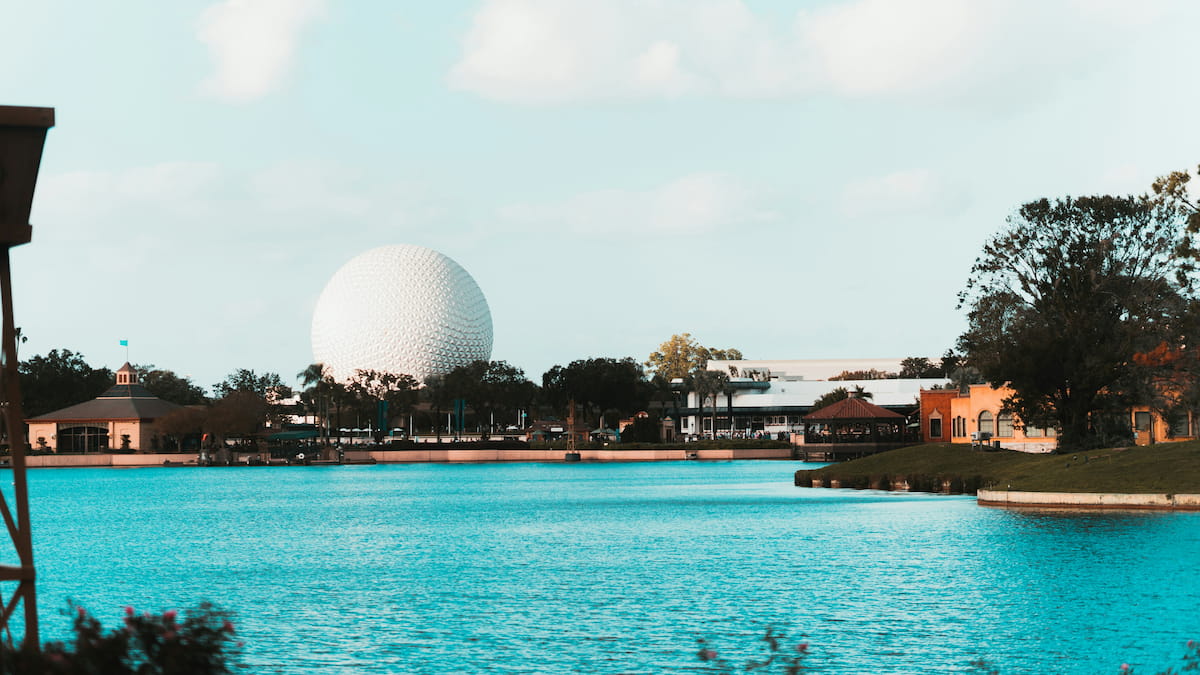 Guests enjoying Discovery Cove water experience with EPCOT's Spaceship Earth visible in the background