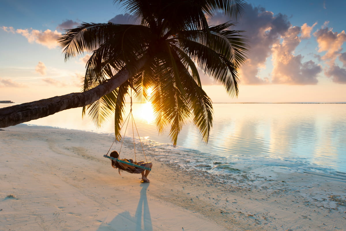 Snorkeler above vibrant Maldives coral reef with colorful fish and clear turquoise water