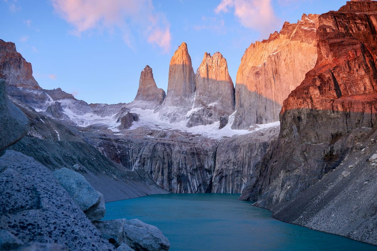 The three granite towers of Torres del Paine rising above a turquoise glacial lake at sunrise, Chilean Patagonia