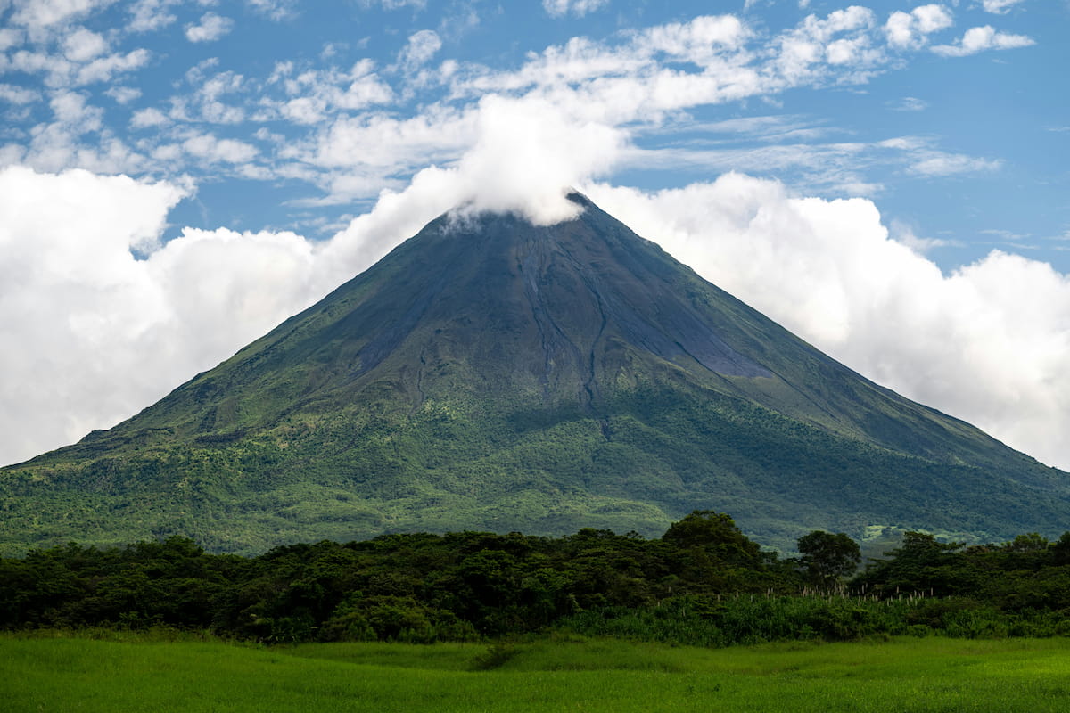 Arenal Volcano rising above rainforest canopy at dawn in La Fortuna, Costa Rica