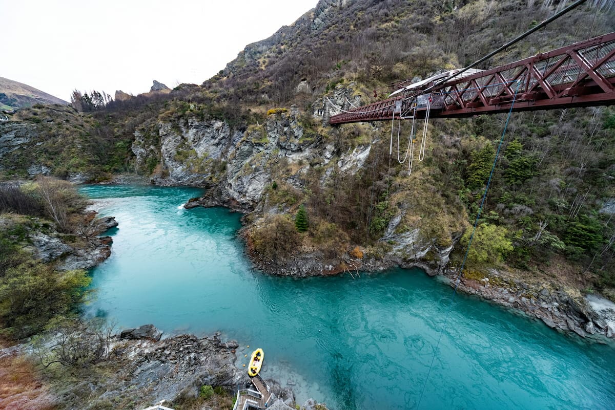 Bungee jumper leaping from the historic Kawarau Bridge above the turquoise Kawarau River, Queenstown