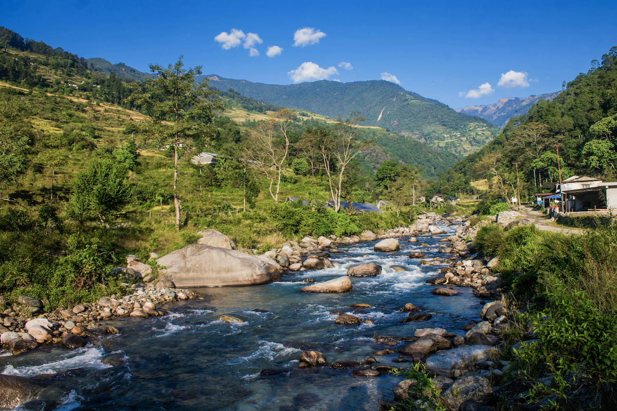 Trekkers on a Himalayan trail with snow-capped peaks behind them, Nepal