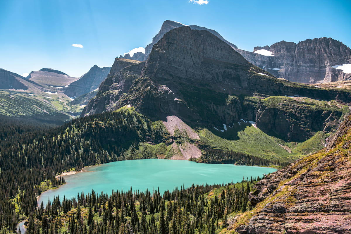 Hiker on the Highline Trail in Glacier National Park with glaciated peaks in the background
